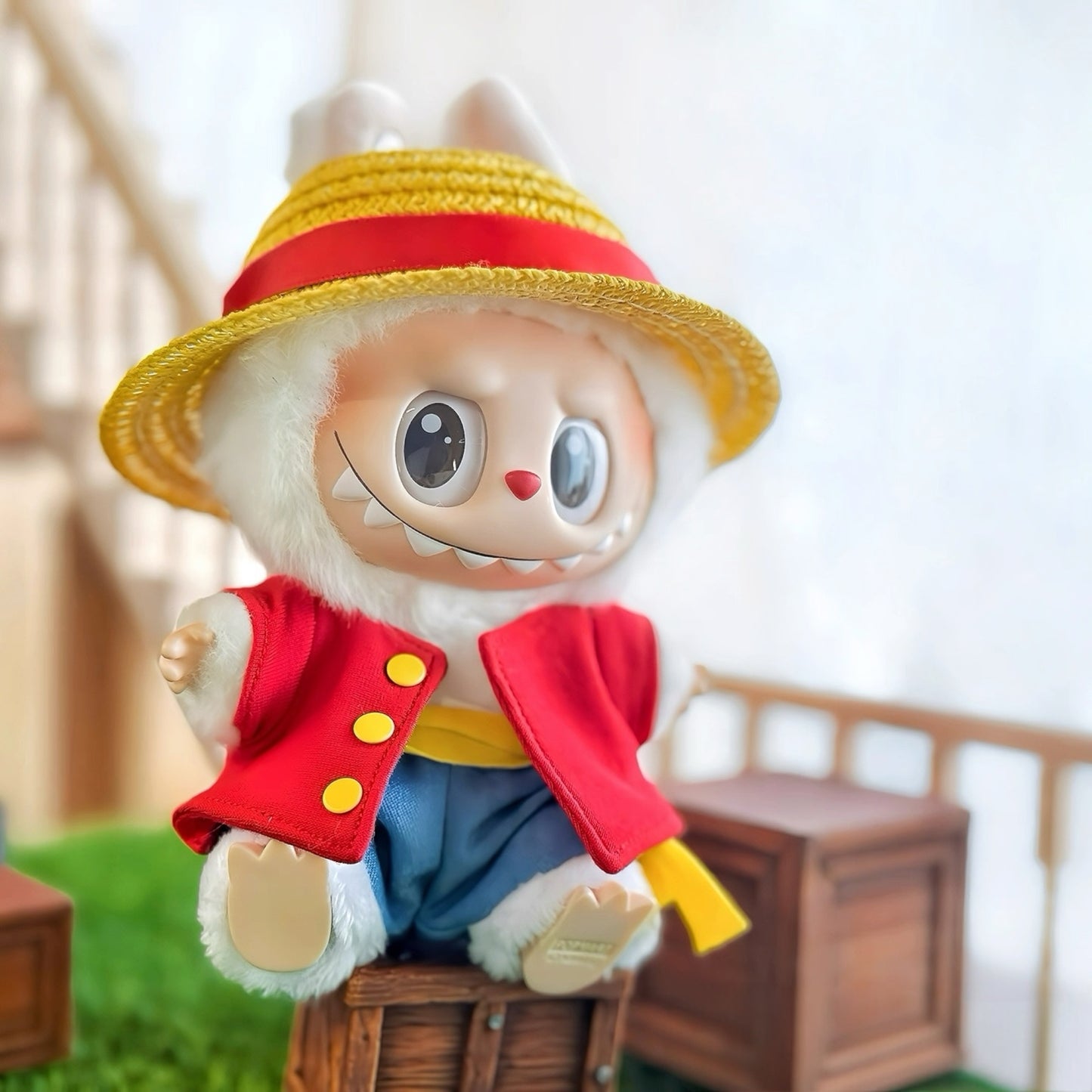 Two plush toys resembling characters One Piece Luffy and Chopper from a popular anime series on grass with a blurred background.