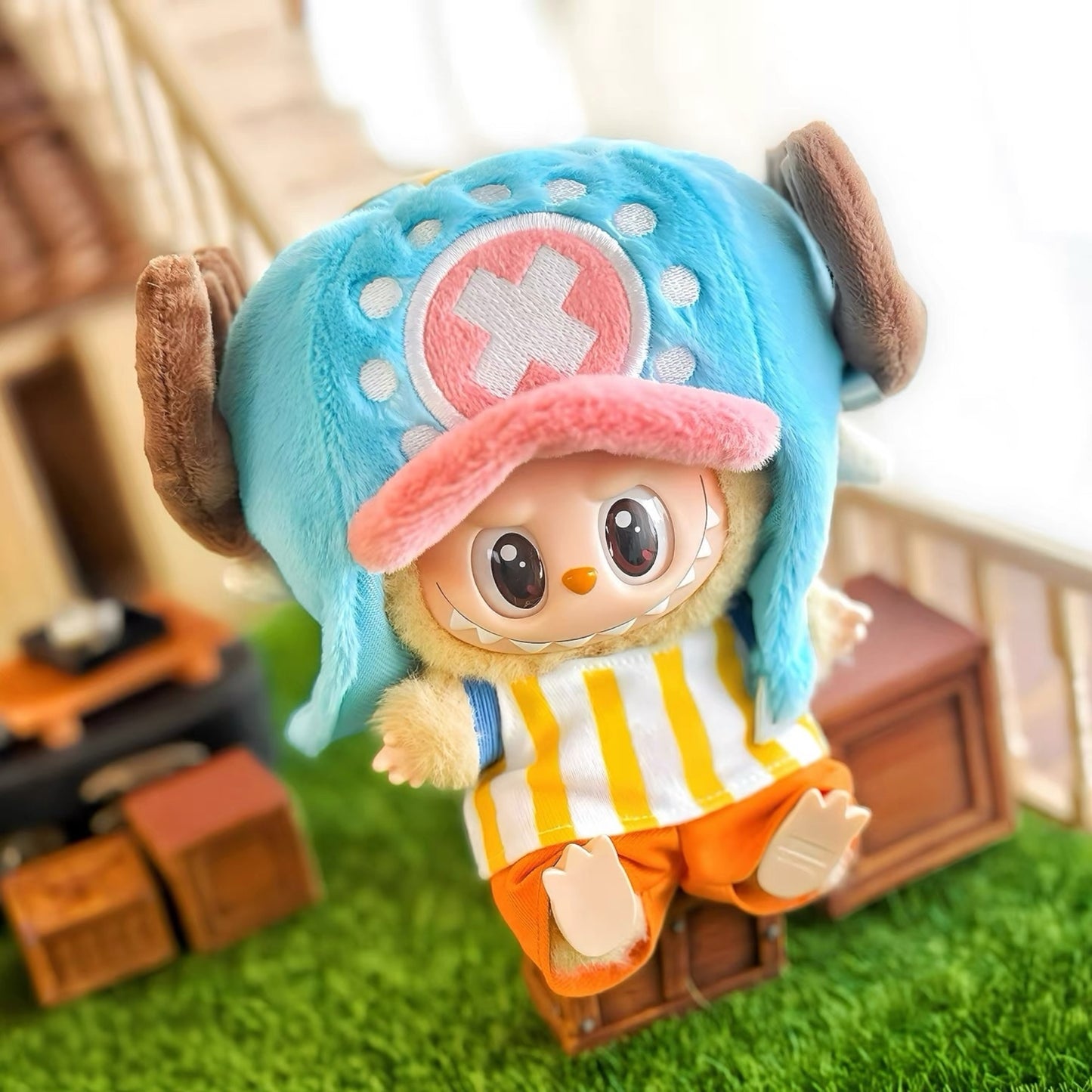 Two plush toys resembling characters One Piece Luffy and Chopper from a popular anime series on grass with a blurred background.