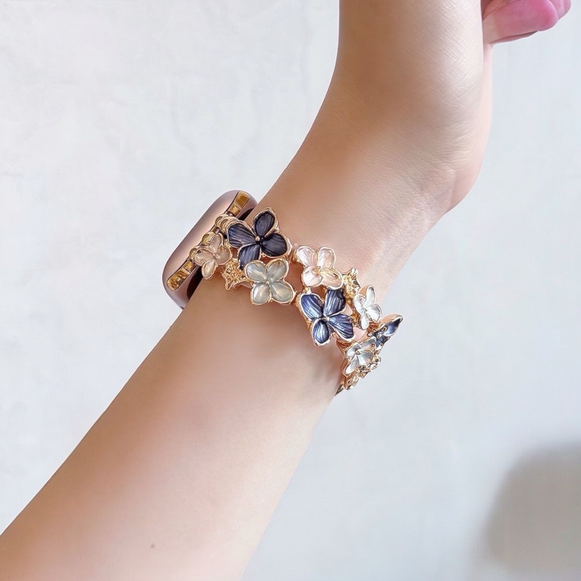 Bangle with floral design on a wrist against a light background