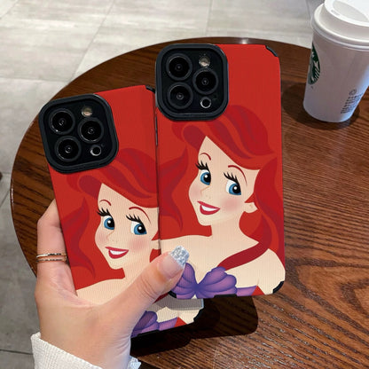 My Little Mermaid Ariel iPhone case with a character design held by a hand on a wooden table with a Starbucks cup in the background.