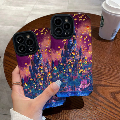 Hand holding a iPhone case with a colorful castle design on a wooden table with a Starbucks cup in the background.