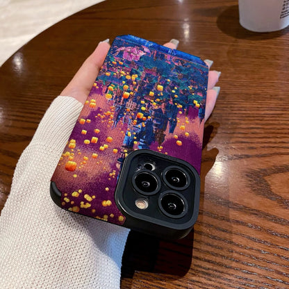 Hand holding a iPhone case with a colorful castle design on a wooden table with a Starbucks cup in the background.