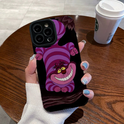 Hand holding a iPhone case with a Cheshire Cat of Alice in Wonderland on a wooden table with a Starbucks cup.