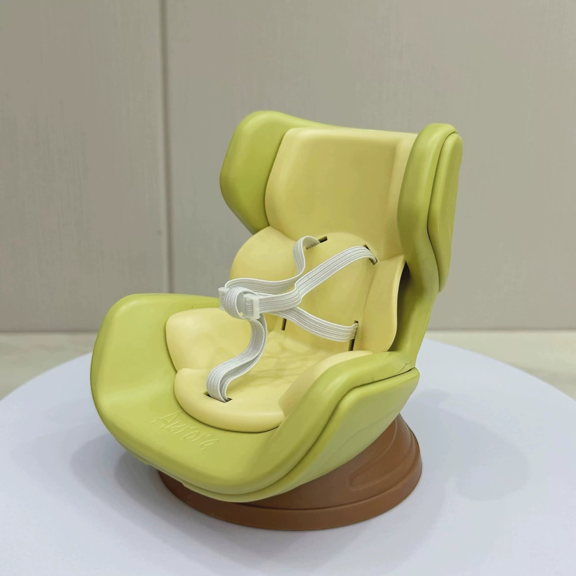 Green baby seat on a white platform with a beige background