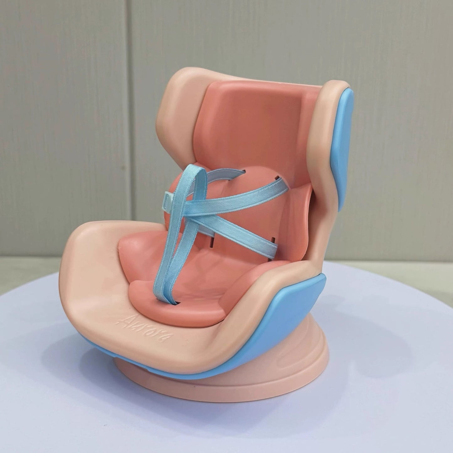 Baby seat with pink and blue design on a white surface