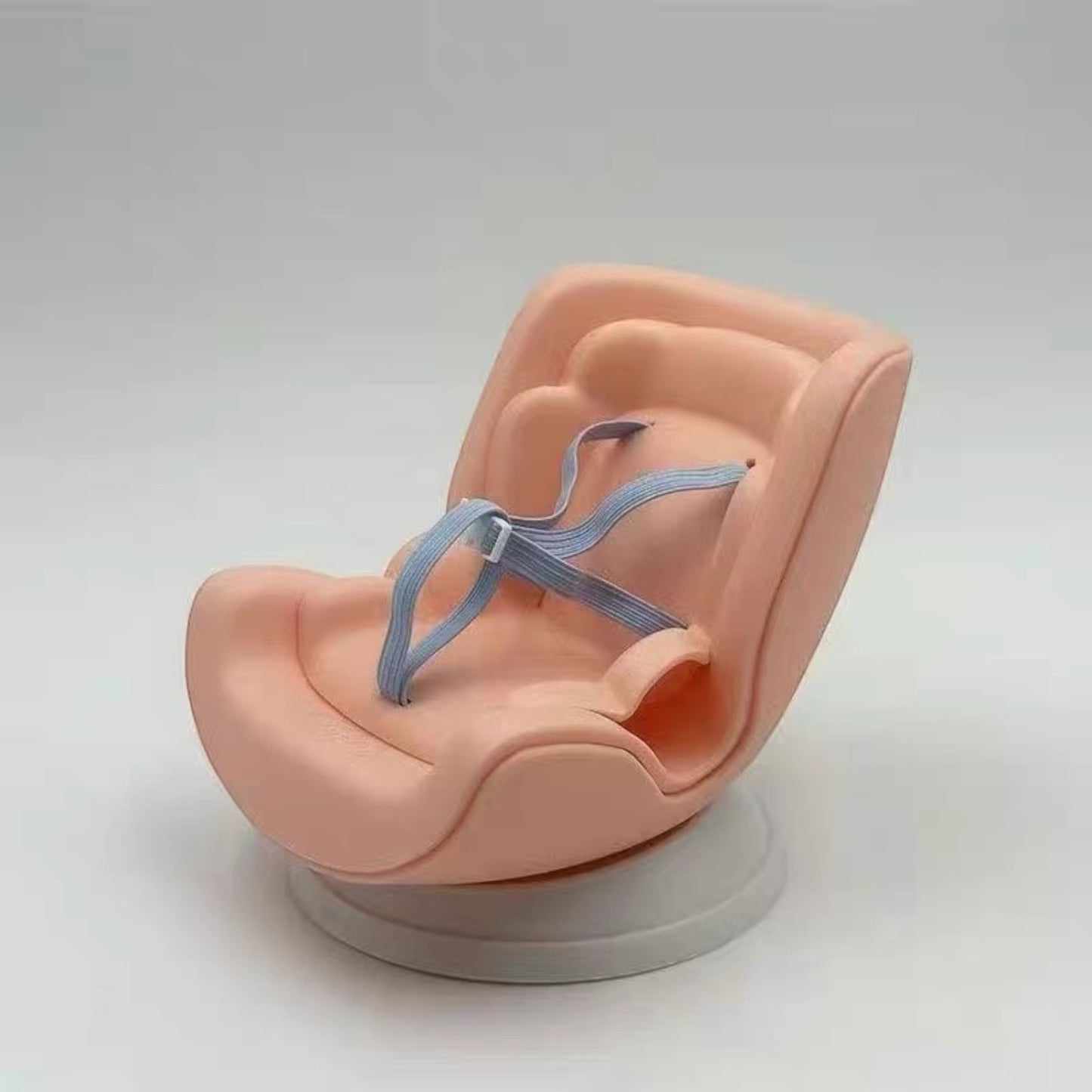 Pink baby seat with a gray strap on a white background