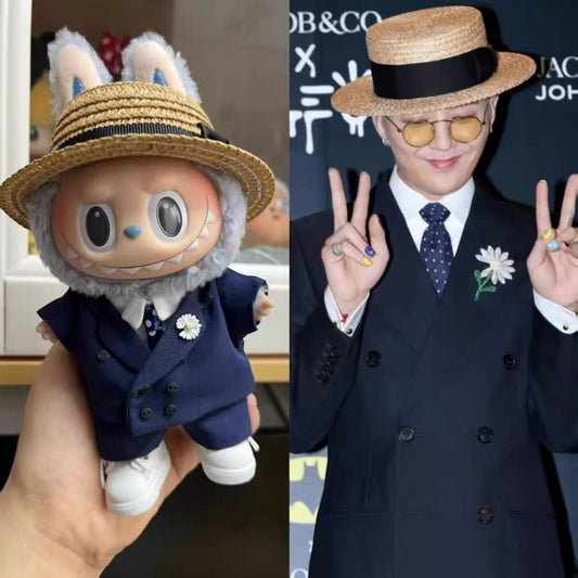 Labubu Keychain Toy figure in a blue suit and hat next to a person is Korea famous pop star G-Dragon in formal attire with a hat and sunglasses.