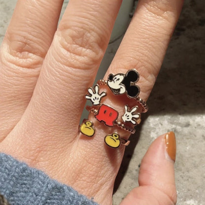 Hand wearing a cartoon-themed Vintage Mickey Mouse ring with a white background
