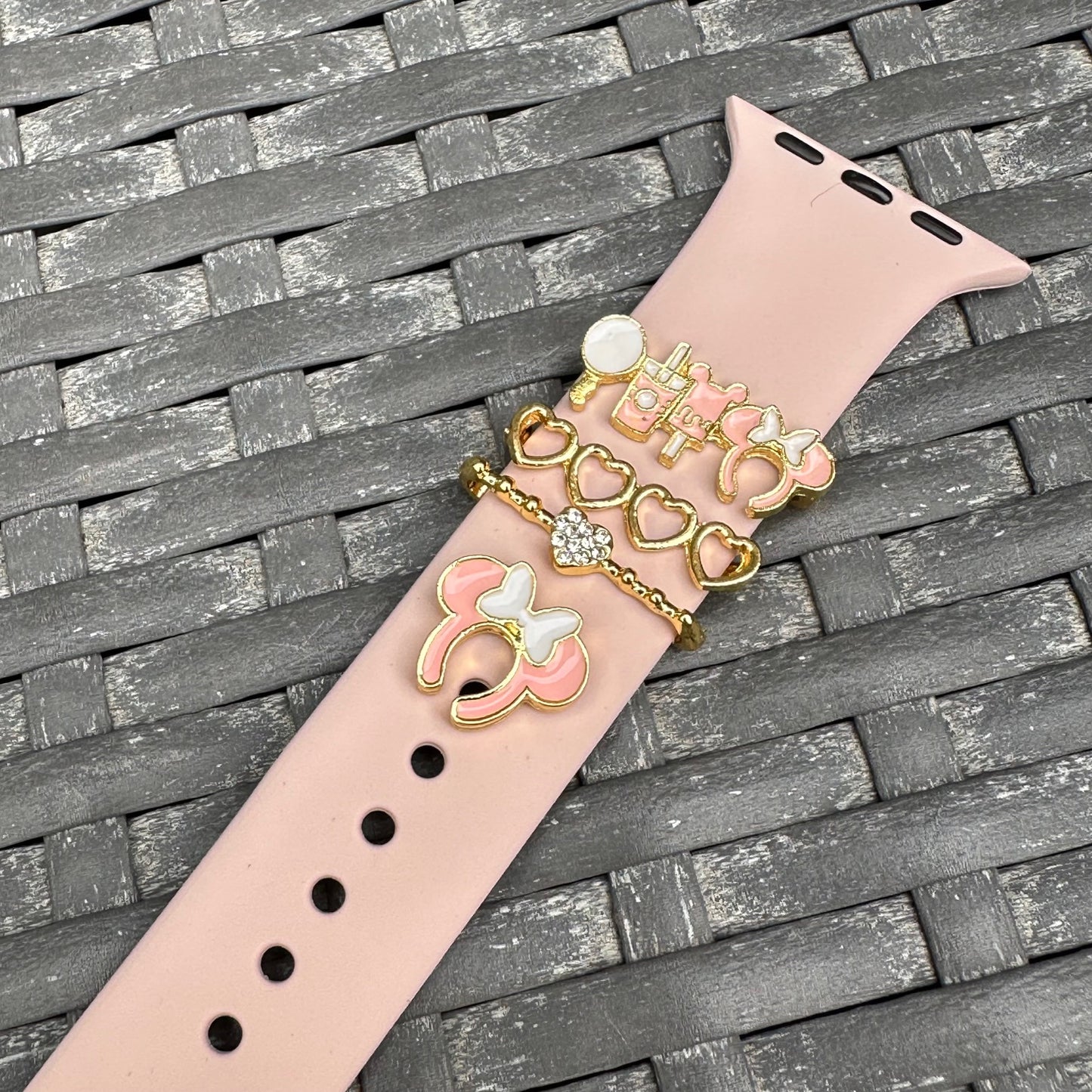 Decorative watch band with minnie mouse theme park snack charms on a textured surface