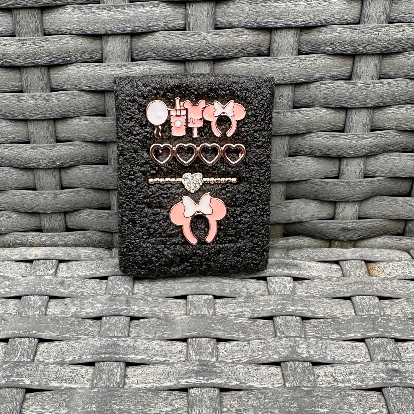Set of decorative minnie mouse theme park snack charms on a textured surface
